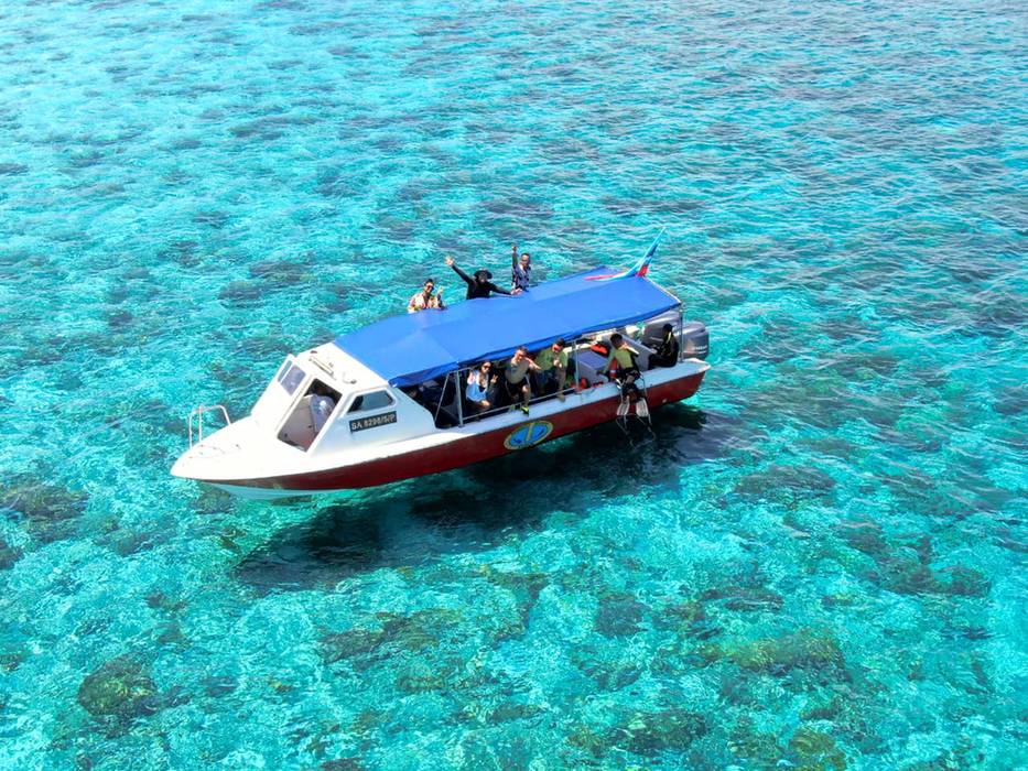Dive boat with a blue canopy over a turquoise reef, seen from above (placeholder, to recheck when the photo is replaced)