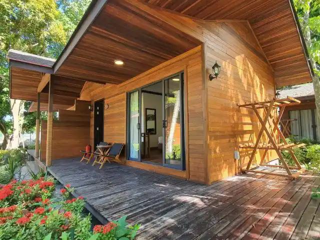 Timber chalet with a wooden deck and red flowers at Borneo Divers Mabul Resort (placeholder, to recheck when the photo is replaced)