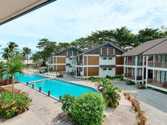 Swimming pool with palm trees and villa buildings behind at Borneo Divers Mabul Resort (placeholder, to recheck when the photo is replaced)