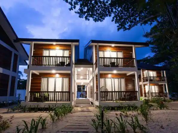Two-storey villa building lit at dusk with balconies at Borneo Divers Mabul Resort (placeholder, to recheck when the photo is replaced)
