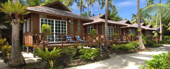 Timber chalets with verandahs and sun loungers under coconut palms on Mabul Island (placeholder, to recheck when the photo is replaced)